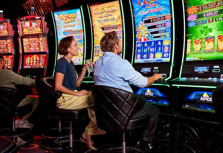 Frau und Mann vor Spielautomaten