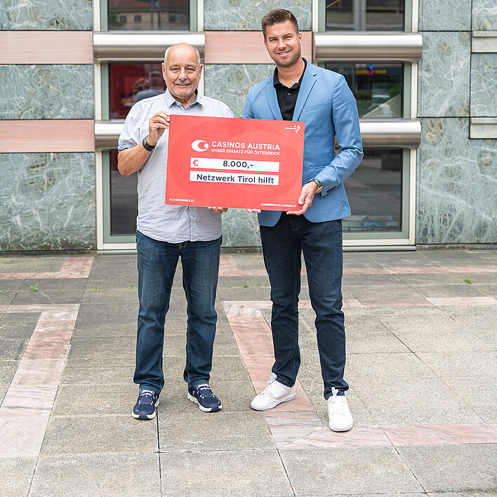 Casino Seefeld Mitarbeiter bei Scheck-Übergabe an Netzwerk Tirol hilft