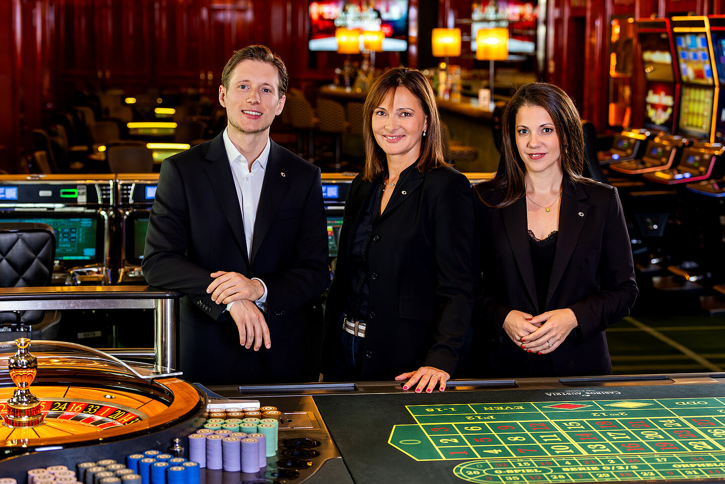 Drei Key Account Manager:innen - ein Herr und zwei Damen - im Casino Wien beim Roulette-Tisch