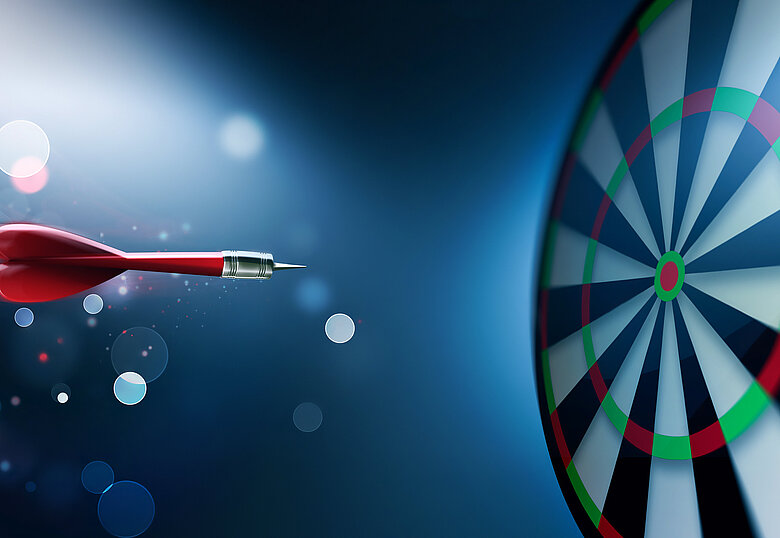 Ein Pfeil fliegt auf eine Dartscheibe zu